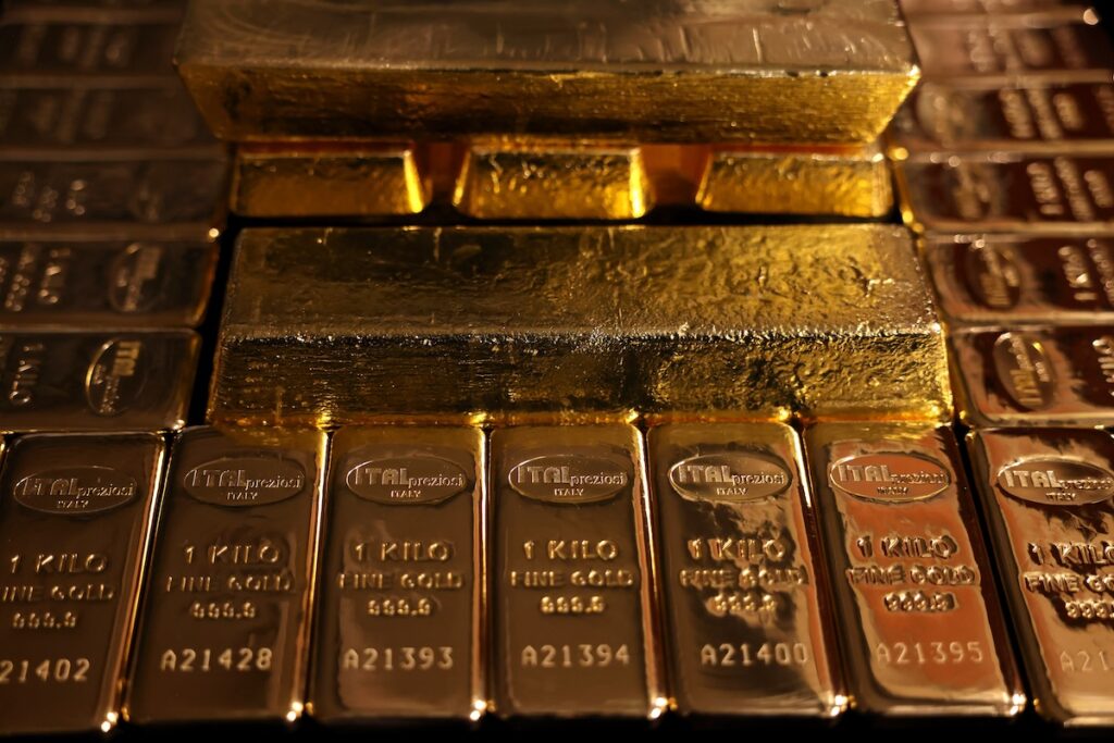 Las pilas de lingotes de oro y plata están dispuestas muy juntas, con los lingotes de oro colocados encima de varios lingotes de plata. Cada lingote lleva estampados el peso, los números de serie y las marcas de refinería.