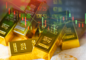 Pila di lingotti d'oro con sovrapposizione di un grafico finanziario, con candele e numeri verdi e rossi, che simboleggiano il mercato dell'oro e le tendenze di investimento.