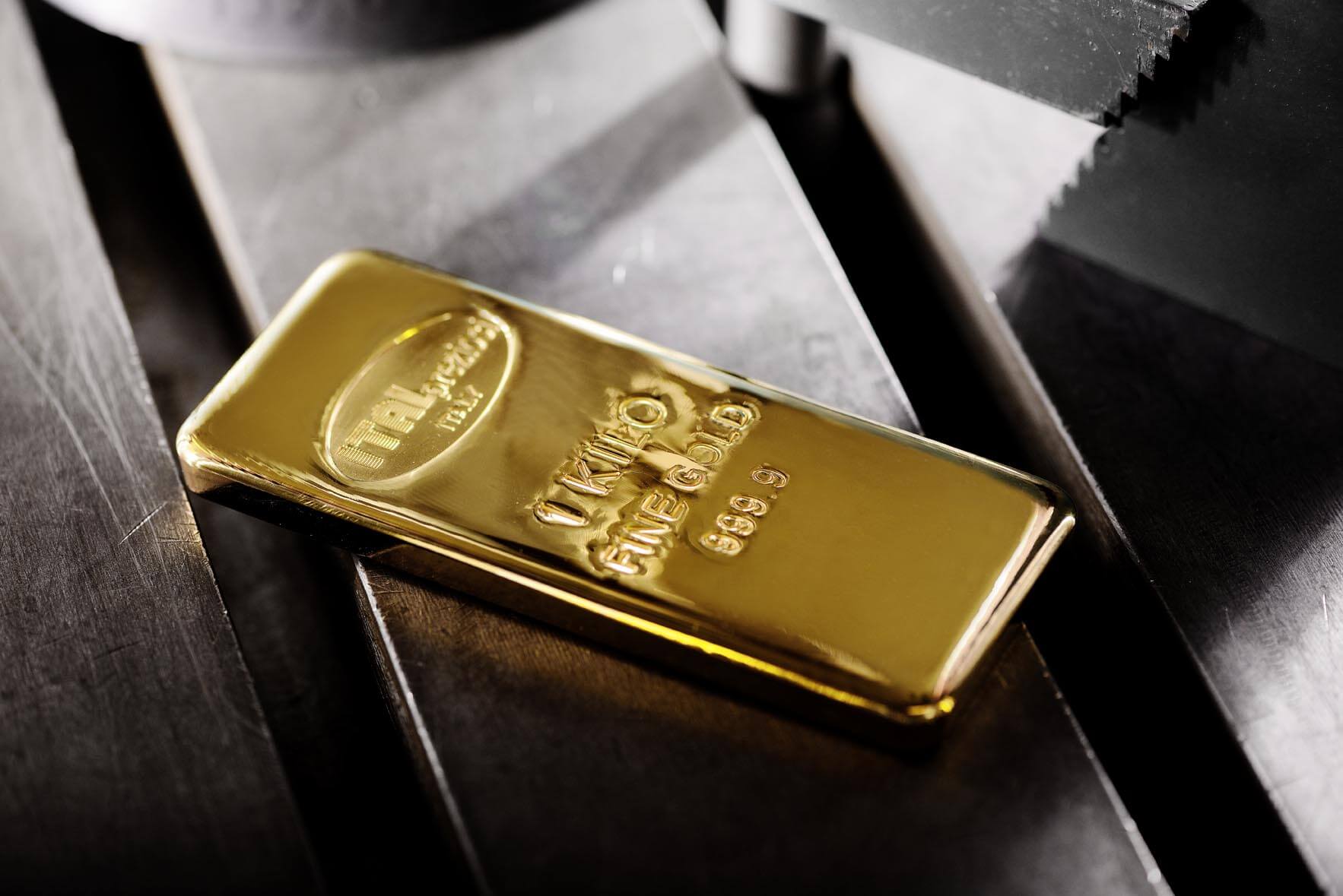 Lingotto d'oro da 1 chilogrammo con purezza 999,9, con logo ovale in rilievo, appoggiato su una superficie metallica scura.